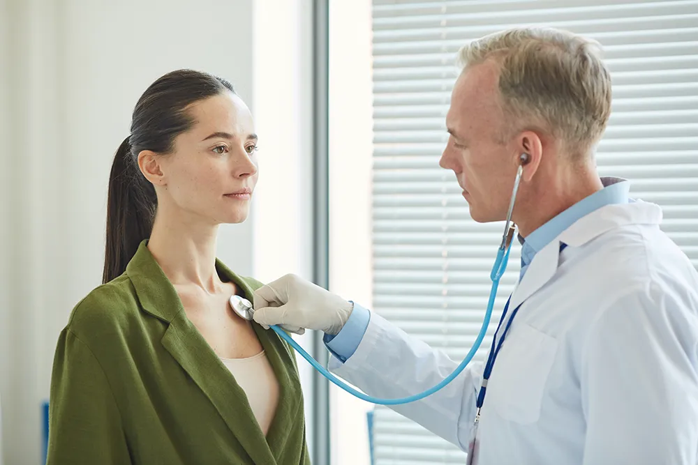 Doctor performing a routine health check during a DOT physical visit for commercial drivers in a professional clinic setting